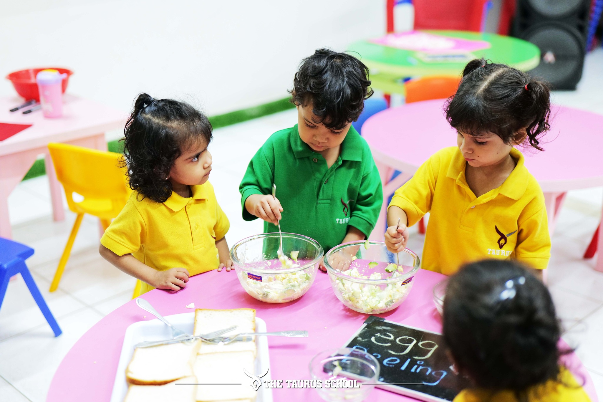 Teacher helping child in colorful classroom