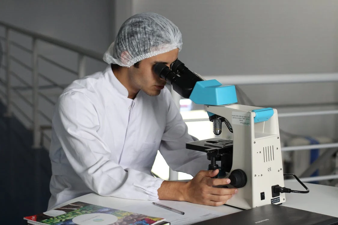 a man is looking from microscope in a laboratory